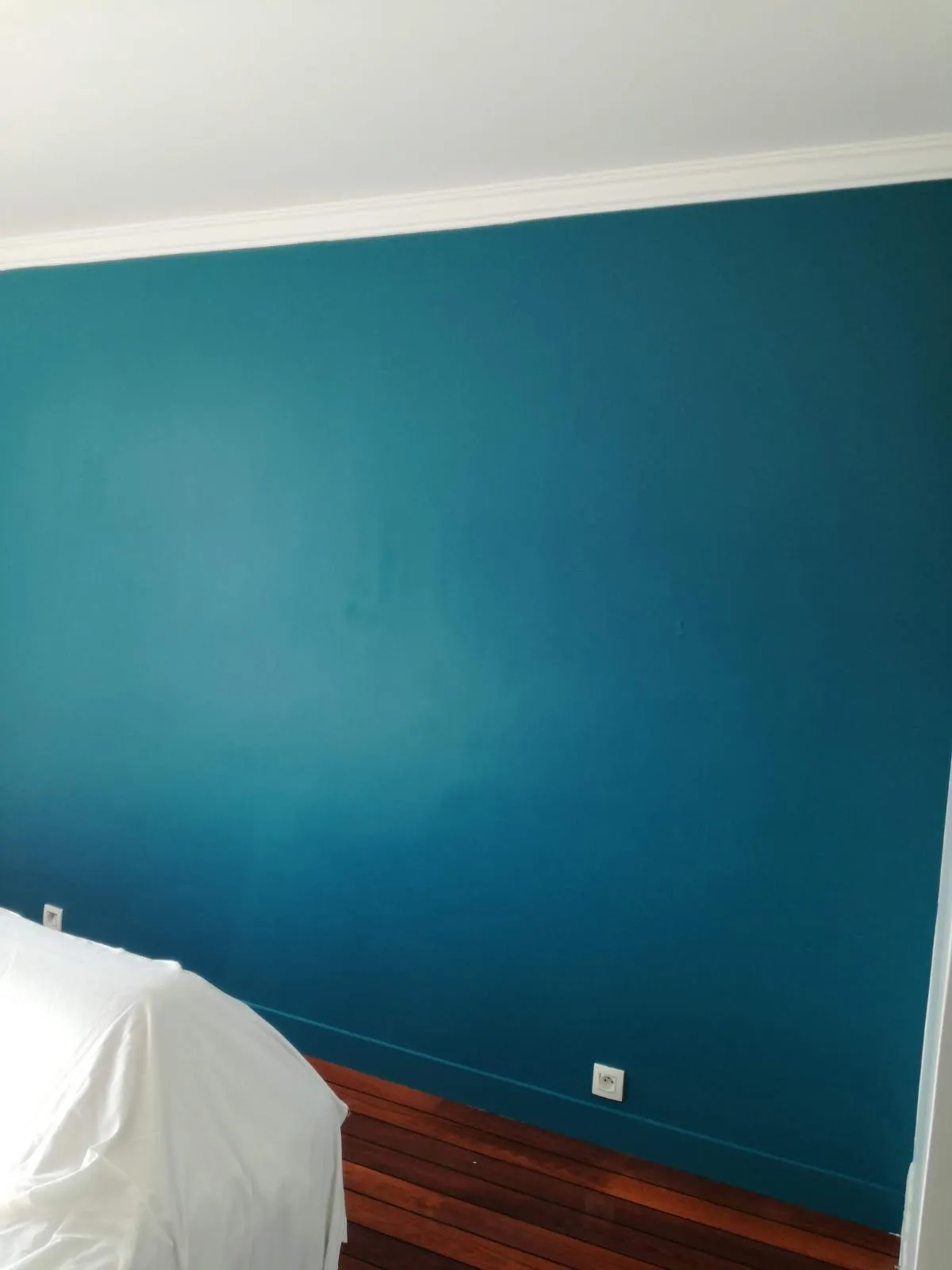Mur bleu profond avec plafond et corniche blancs